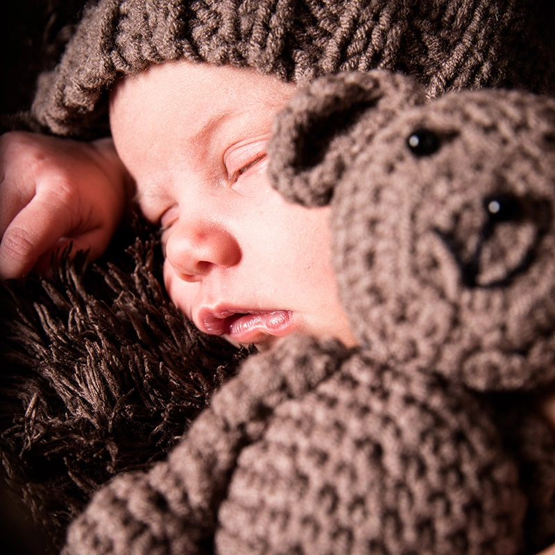 Photo de bébé avec mini peluche en studio par Laurent Bossaert